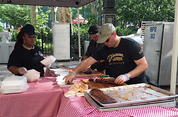 Cutting and plating ribs at Dinosaur BBQ booth