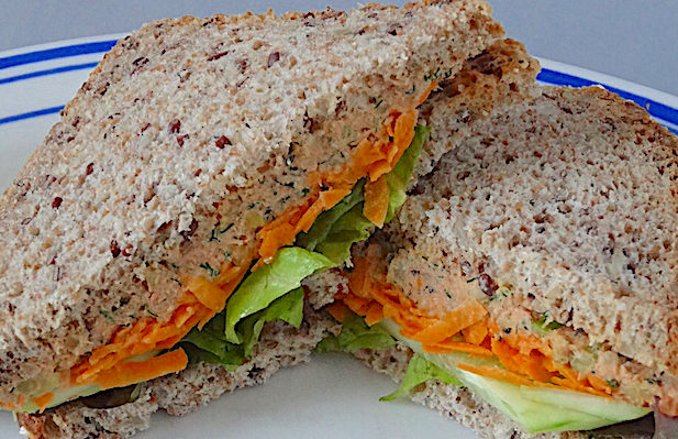 Salmon Salad Sandwich with grated carrots, lettuce and cucumber on whole grain bread